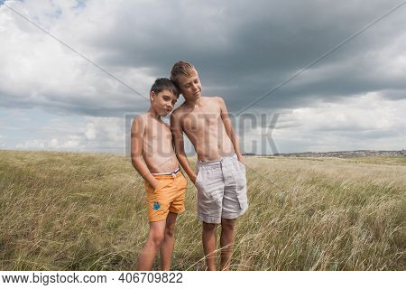 Boys Standing In A Field . Boys In Shorts.   Two Friends. Children Playing In The Field.