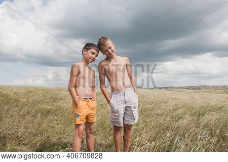 Boys Standing In A Field . Boys In Shorts.   Two Friends. Children Playing In The Field.