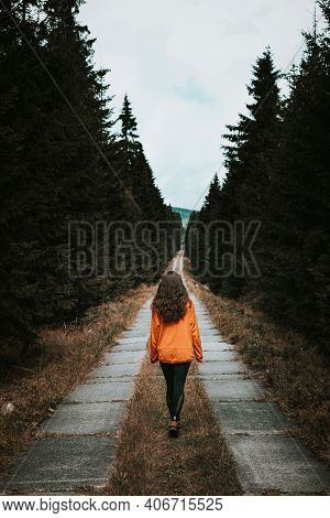 Magical Brunette Aged 20-24 In A Glowing Orange Sweatshirt On The Road In The Jizera Forests. Hiker 
