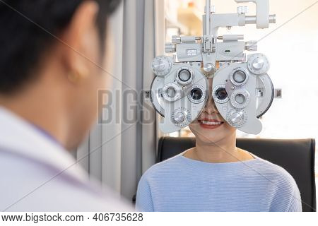 Selective Focus At Optometry Frame Equipment. While Doctor Using Penlight And Subjective Refraction 