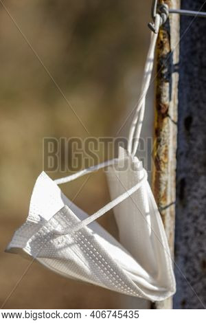 Surgical Mask Abandoned On A Mountain Path And Hung On A Pole By A Passer-by.