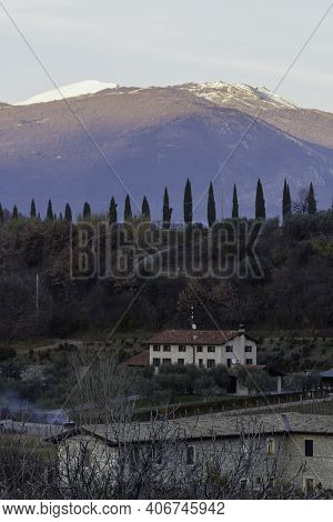 Splendid View Of The Snow-covered Monte Baldo And The Path With Cypresses From The Velleselle On The
