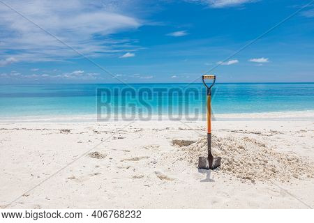 Shovel In Sand At The Beach. Wide Angle Image Of A Rusty Shovel In The Sand On A Beach