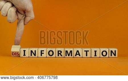 Information Or Disinformation Symbol. Businessman Flips A Cube And Changes The Word Disinformation T