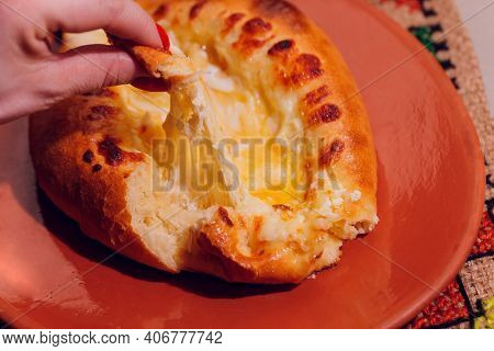 Woman Is Eating Adjarian Khachapuri With Hands, Crushing Egg Yolk.