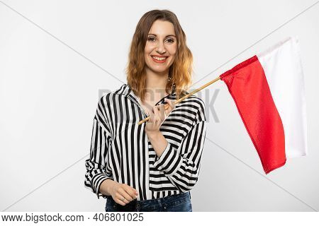 A Smiling Girl Holds One Polish National Flag In Her Hand. Isolated From The Background.