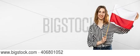 A Smiling Girl Holds One Polish National Flag In Her Hand. Isolated From The Background. A Shot In A