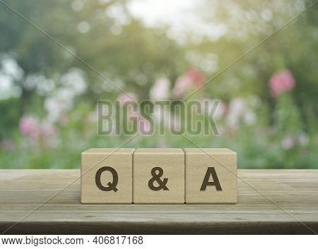 Q And A Word On Block Cubes On Wooden Table Over Blur Pink Flower And Tree In Garden, Frequently Ask