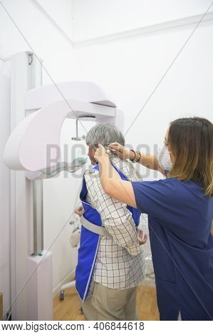 Dentist Helps Patient Put On Lead Vest For A Panoramic X-ray. Dental Health Care Concept