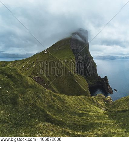 Kalsoy Island With Kallur Lighthouse On On Faroe Islands, Denmark, Europe. Clouds Over High Cliffs, 