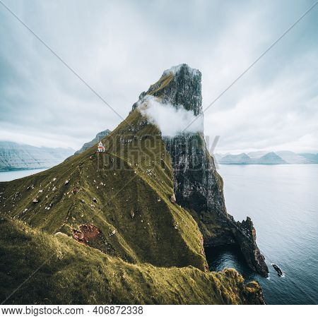 Kalsoy Island With Kallur Lighthouse On On Faroe Islands, Denmark, Europe. Clouds Over High Cliffs, 