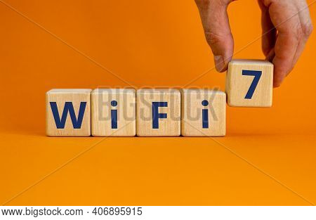 Wifi 7 Symbol. Businessman Holds A Wooden Cube With Words Wifi 7. Beautiful Orange Background, Copy 