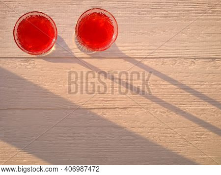 Couple Glasses With Red Wine On The Wooden Background With Sunligt. Abstract Food Background. Top Vi