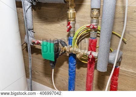 Water Circulation Pump For Underfloor Heating In A Modern Gas Boiler Room Lined With Ceramic Tiles.