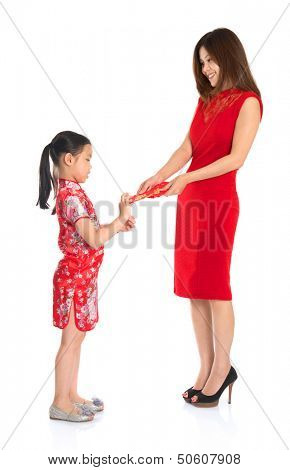 Asian Chinese child receiving red paper packet or monetary from parent on Chinese New Year festival, with traditional Cheongsam isolated on white background.