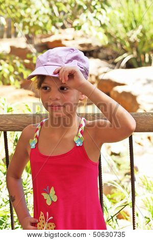 Sweet seven-year-girl in a pink sarafan trimmed appliquÃ?Ã?Ã?ÃÂ©s in the form of butterflies, and satin cap