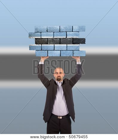 Businessman Holding A Large Piece Of A Brick Wall