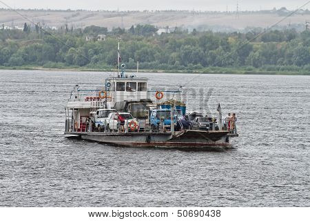 transportation of trucks on a small ferry across the Volga.