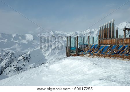 Deckchairs standing on peak In Alps In Winter