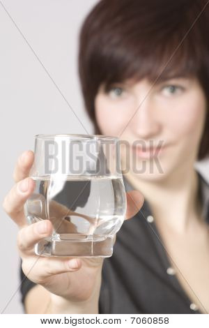 Ung kvinde med glas vand i hånden