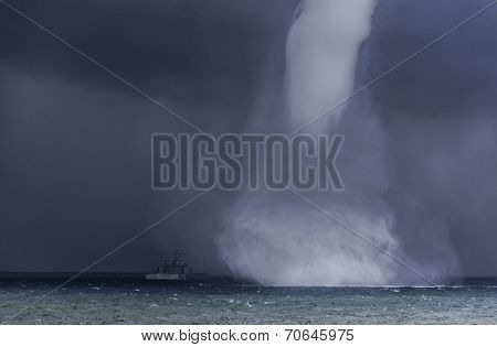 Spectacular waterspout approaching a boat
