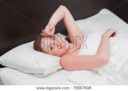 Smiling Young Woman Wakes Up On Bed