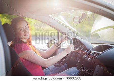 Beautiful smiling redhead woman traveling by car