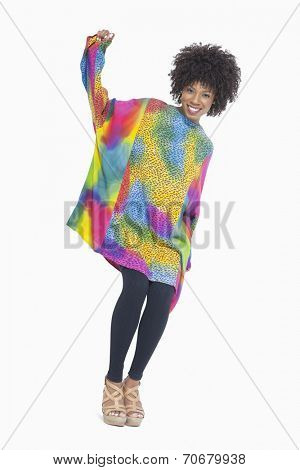 Full length portrait of an African American woman in dashiki standing over gray background