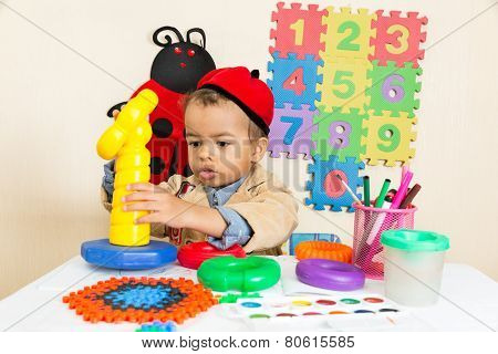 African American Black Boy Drawing With Colorful Pencils In Preschool At Table In Kindergarten