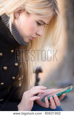 Young woman typing on phone.