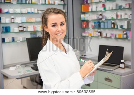 Pharmacy intern writing on clipboard at the hospital pharmacy