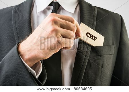 Businessman Removing A Wooden Card With Chf Sign