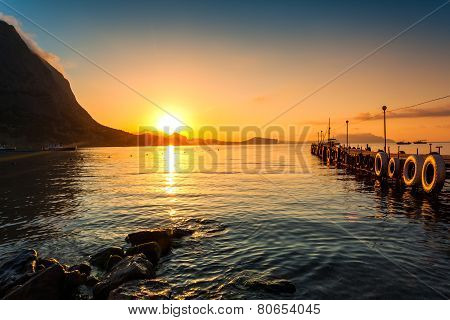 Beautiful golden sunset above the sea and mountain
