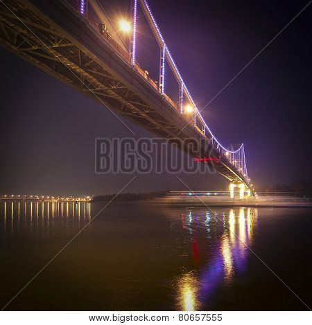 Illuminated pedestrian bridge on the Dnieper River Kiev Ukraine