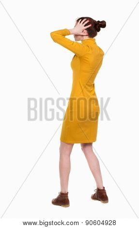 Back view of shocked woman in dress .   upset young girl. Rear view people collection.  backside view of person.  Isolated over white background. A woman in a dress is shocked by what he saw.