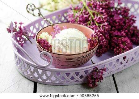 Beautiful composition with tasty ice cream and lilac flowers