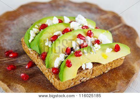 Avocado with Feta, pomegranate on sunflower seeds bread sandwich
