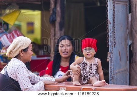 Little Girl With Glasses Presumably With Down Syndrome Is Enjoying Being With Her Mother And Grandmo