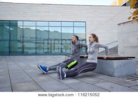couple doing triceps dip exercise outdoors