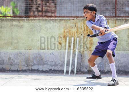 KOLKATA, INDIA - APRIL 14, 2013: Poor indian boy plays cricket after receiving his new glasses