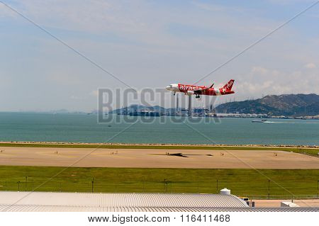 HONG KONG - JUNE 04, 2015: Air Asia aircraft landing at Hong Kong airport. AirAsia Berhad is a Malaysian low-cost airline headquartered near Kuala Lumpur, Malaysia.