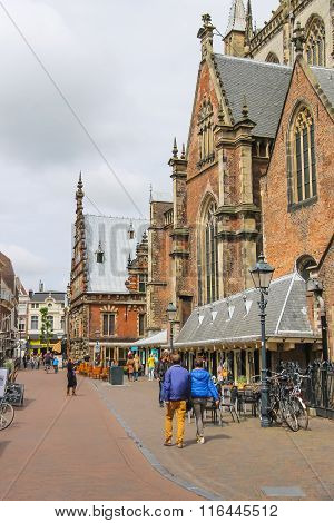 People Walking Near The Grote Kerk (sint-bavokerk) In The  Historic Center Of Haarlem, The Netherlan