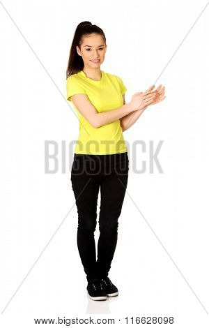 Young happy clapping woman.