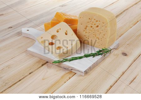 various types of fresh raw aged delicatessen cheese on white plate over light wooden table cheddar edam swiss