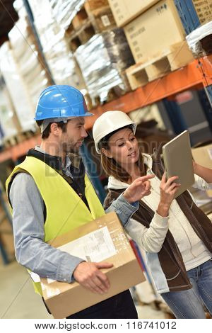 Store manager with warehouseman checking stock levels