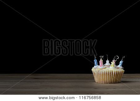 Birthday Cupcake With Candles Blown Out On Black