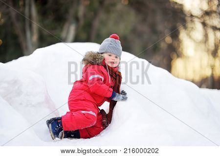 Little Boy In Red Winter Clothes Having Fun With Fresh Snow