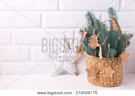 Christmas ster simple wooden toys and branches fur tree on white wooden background. Decorative christmas composition. Selective focus. Place for text.