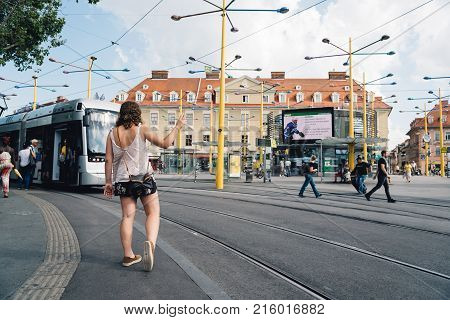 Graz, Austria - August 11, 2017: People waiting for tram in square in historical city center of Graz.