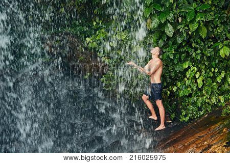 Handsome man bathing in waterfall in pure nature. Chiang Mai Province Thailand